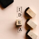 Artistic flat lay of wooden blocks spelling 'IDEA' with ink pad, perfect for DIY inspiration.